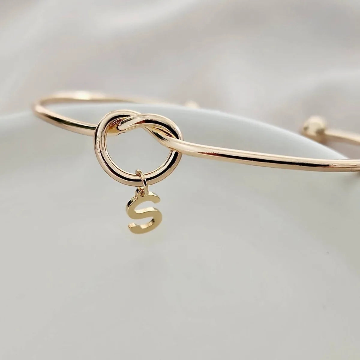 "Gold Initial Charm Bangle Bracelet" can be rewritten as "Personalized Gold Initial Charm Bangle".