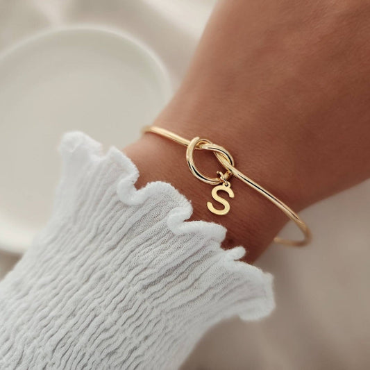 "Gold Initial Charm Bangle Bracelet" can be rewritten as "Personalized Gold Initial Charm Bangle".